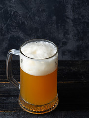 A mug of unfiltered wheat beer on a dark background