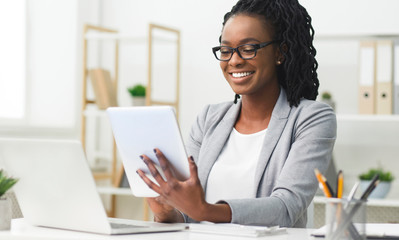 Afro Business Lady Using Digital Tablet And Laptop In Office