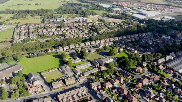 Aerial footage of the UK town known as Pontefract, located in Wakefield West Yorkshire, showing typical British housing estates with roads and paths.