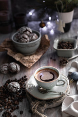 Obraz na płótnie Canvas Cup of coffee with coffee beans and chocolate chip cookie with fried New Year lights on a beautiful brown background.