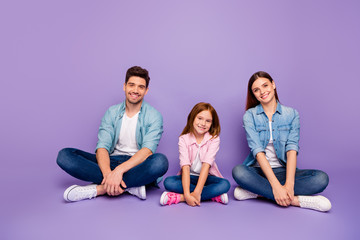 Fototapeta na wymiar Family of three members sitting floor enjoy best company wear casual clothes isolated purple background