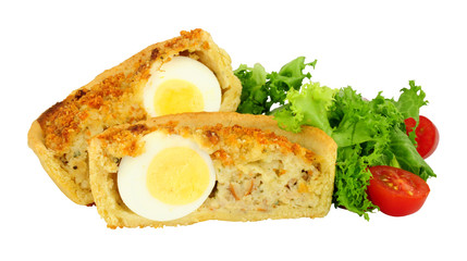 Scotch egg quiche with shortcrust pastry and whole egg encased in pork sausage meat with fresh salad isolated on a white background