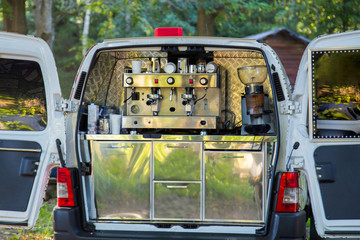 Mobile coffee catering van with professional coffee machine in trunk of car at outdoor city festival. Street food concept