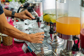 Fresh juice at buffet restaurant, with self service man hand