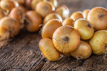 bundle of freely lying dried onion on a wooden table