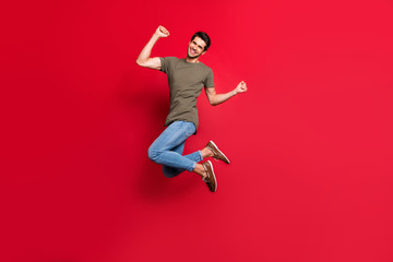 Full body photo of amazing guy jumping high childish mood wear casual outfit isolated on red background