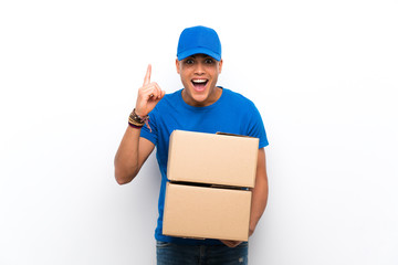 Delivery man over isolated white wall pointing up a great idea