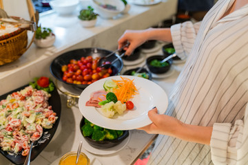 Woman hand taking food in buffet