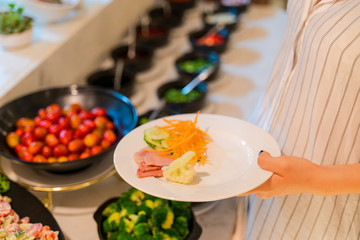 Woman hand taking food in buffet