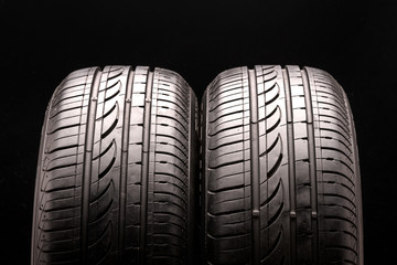 two summer tires on black background. close up