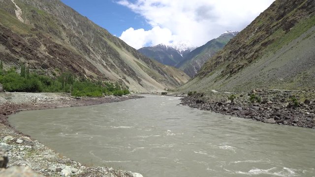 Kulob to Qalai Khumb Pamir Highway along the Panj River with View of Snow Capped Mountains on the Afghanistan Side on a Sunny Blue Sky Day