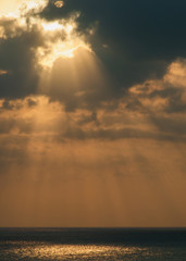 The evening rays of the sun over the Mediterranean Sea. Yellow clouds background