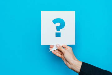 cropped view of woman holding speech bubble with question mark on blue - obrazy, fototapety, plakaty
