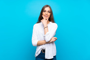 Young woman over isolated blue background smiling