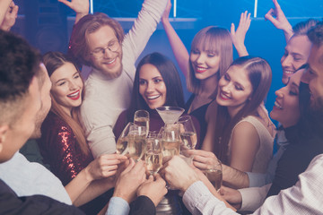 Portrait of nice charming adorable glamorous fascinating attractive gorgeous cheerful cheery glad ladies and guys having fun clinking wineglasses sparkles birthday at fogged lights nightclub