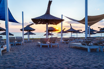 Fototapeta premium Sunrise at Vama Veche, Romania, seen among the sunbeds