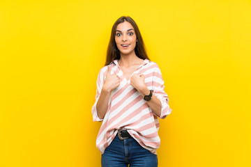 Young woman over isolated yellow background with surprise facial expression