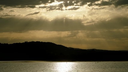 Seascape. Beautiful rays of sun breaking through the clouds over Mediterranean sea and mountain. Greece. 4K