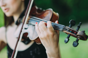 beautiful girl with long hair plays the violin in the forest