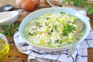 Italian cuisine. Stracciatella zucchini soup: parsley, eggs and parmesan cheese