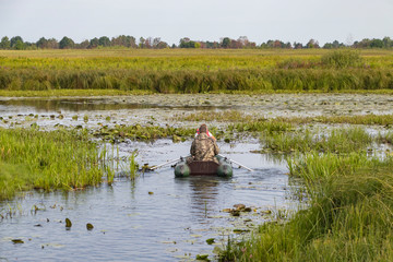 Fishermen in a boat swim in a pond