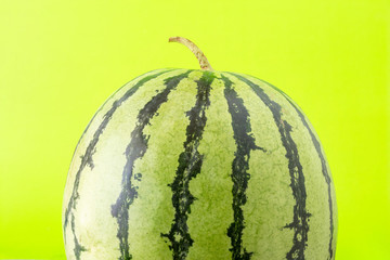Single half of green watermelon isolated on green background. Close up