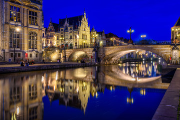 Fototapeta na wymiar View of Graslei, Korenlei quays, Leie river and St Michael's bridge in the historic city center in Ghent (Gent), Belgium. Architecture and landmark of Ghent. Night cityscape of Ghent.