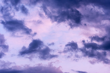 Obraz premium Blue hour sky clouds background. Beautiful landscape with stormy clouds and purple sun on sky