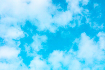Teal blue sky with puffy clouds, an abstract background