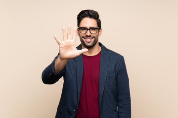 Handsome young man over isolated background counting five with fingers