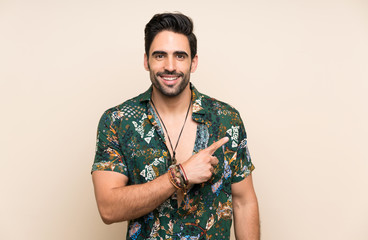 Handsome man in summer shirt over isolated background pointing finger to the side