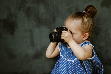 little girl in a beautiful dress learn to take pictures