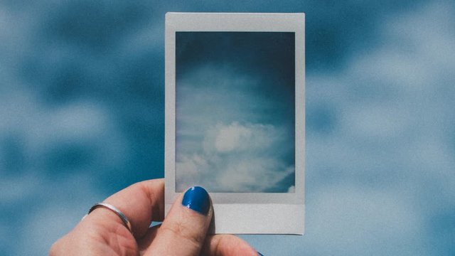 Cinemagraph holding picture of clouds with airplane flying through
