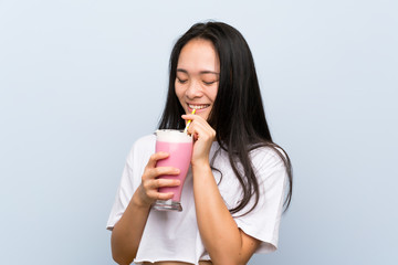 Teenager asian girl holding a strawberry milkshake