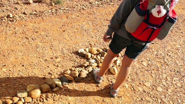 way of st James to Compostela , pilgrim woman with arrow signal made of pebbles , video hd footage