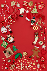 Christmas background border with gold noel sign, tree decorations, symbols and ornaments on red background with copy space. Traditional theme with symbols for the festive season.