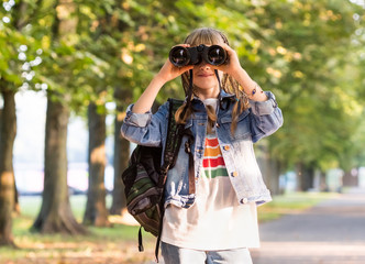 Teenage girl with binoculars in a park