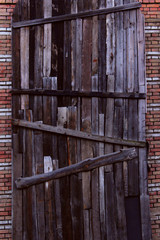 Boarded up windows on a brick wall. Abstract wooden background. Brick wall and wood panels.