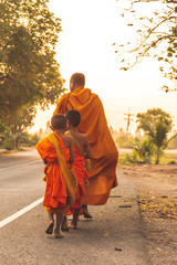 Buddhist monks in a rows with alms bowl walking on the street in the morning.