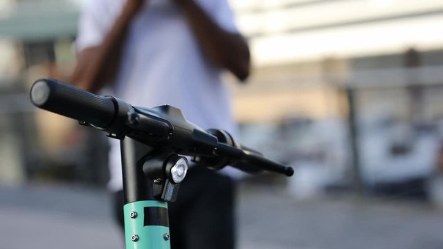 Man walking towards his e-scooter