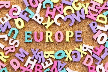 Color alphabet in word Europe with another letter as frame on cork board background
