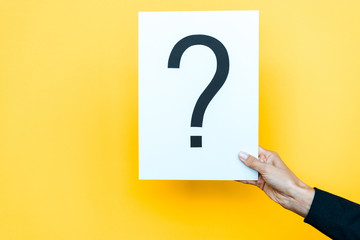 cropped view of woman holding board with question mark on orange