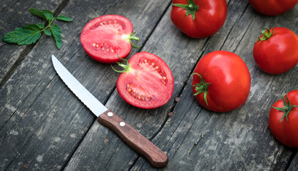 tomatoes and knife on a wooden background