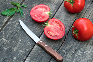 tomatoes and knife on a wooden background
