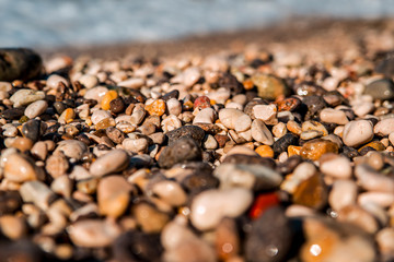 beautiful clear sea. a wave swam across the colored sea pebbles on the shore.