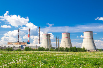 City power plant towers, sunny day.