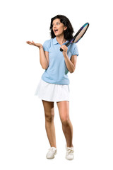 A full-length shot of a Young tennis player woman with surprise facial expression over isolated white background