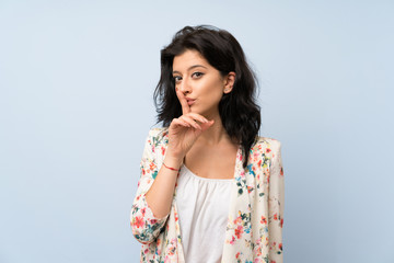 Young woman over isolated blue background doing silence gesture