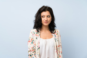 Fototapeta premium Young woman over isolated blue background standing and looking to the side