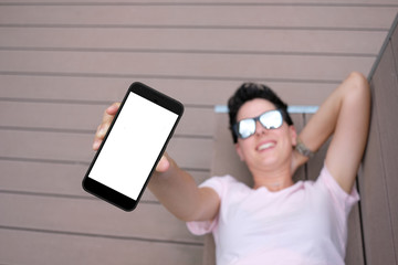 Girl lying showing the screen of her smartphone